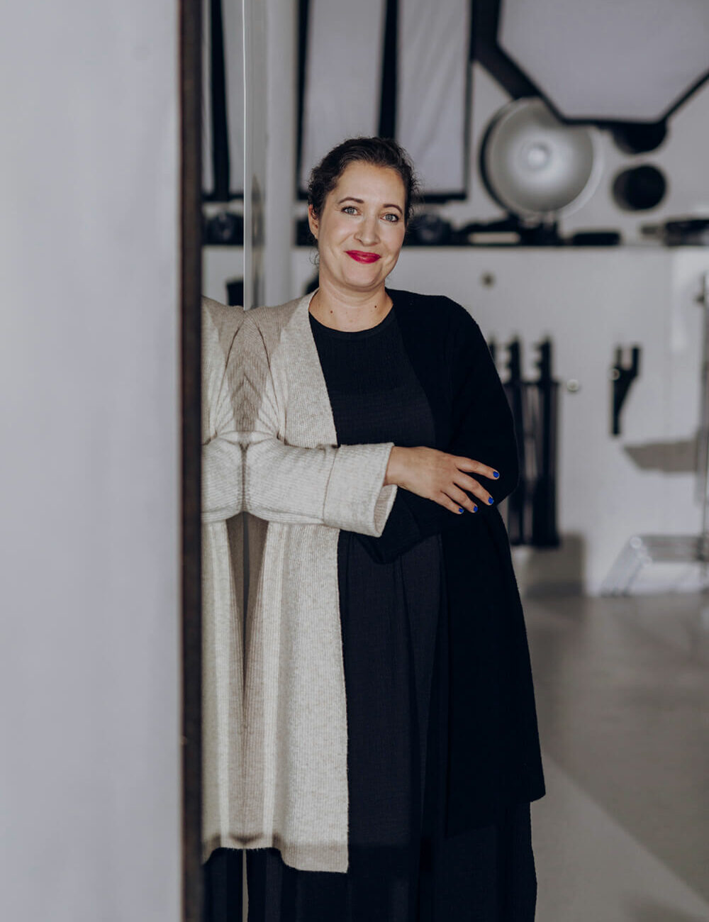 Portrait von Saskia und schwarzem T-Shirt mit schwarz-weißer Strickjacke.