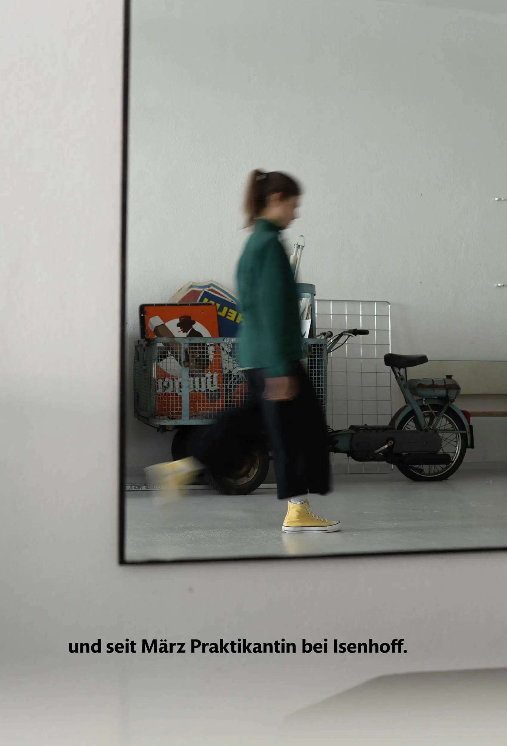 Denise läuft durch die Agentur und spiegelt sich im Spiegel.