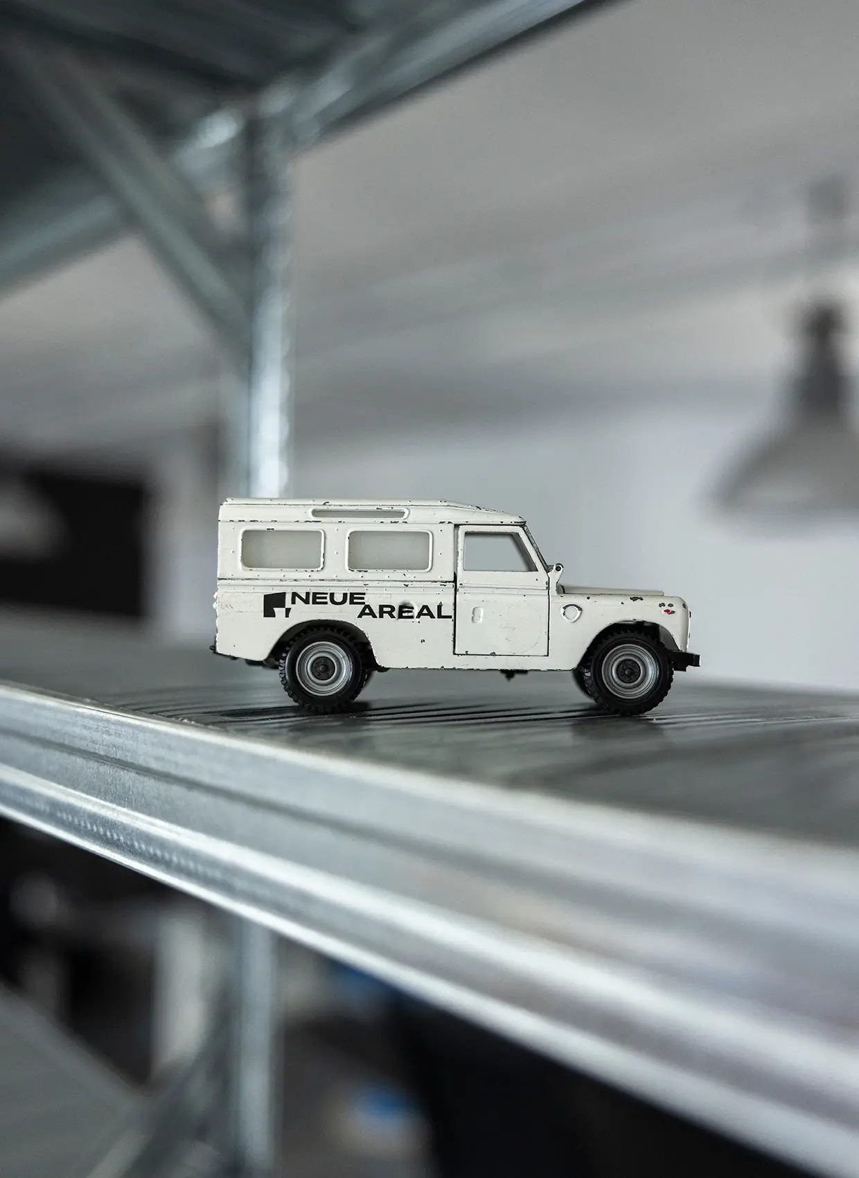 Weißes Spielzeugauto mit Neue Areal Logo