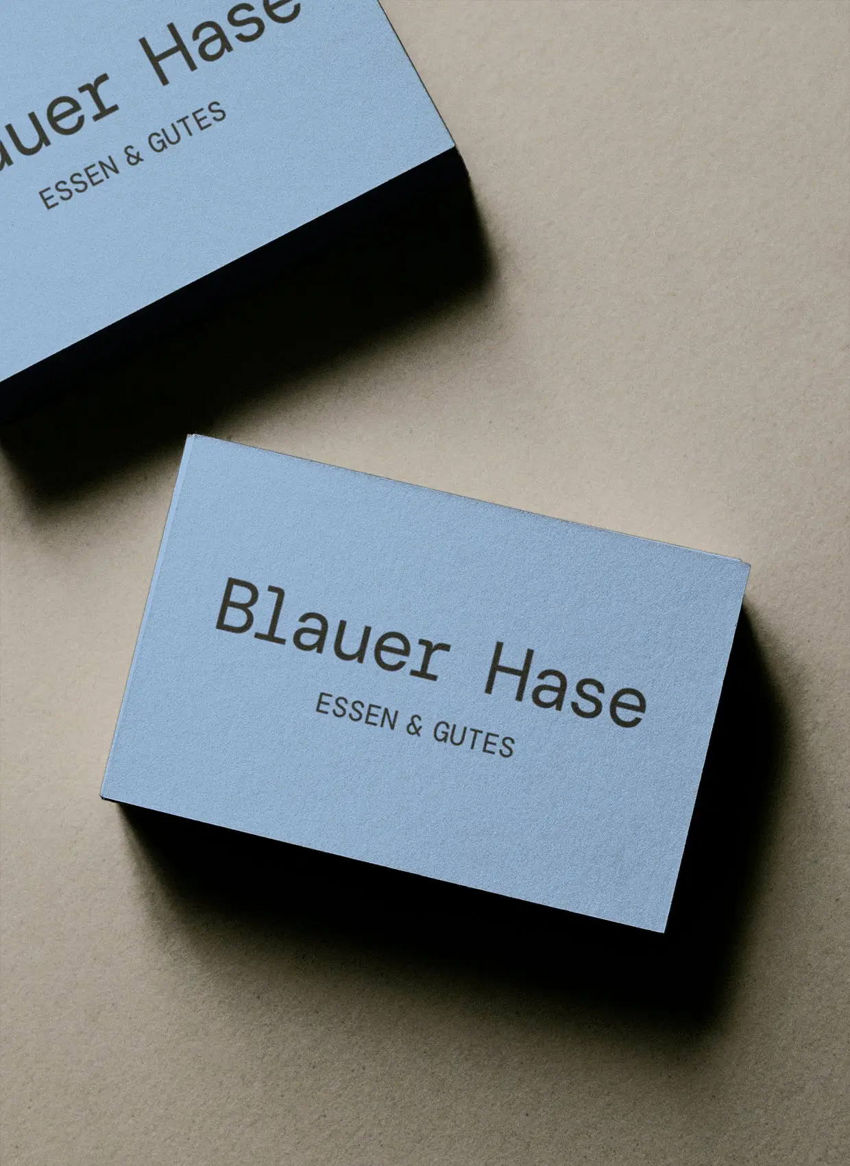 Visitenkarten mit Hintergrundfarbe Hase Blau light und schwarzer Wortmarke "Blauer Hase, Essen & Gutes"