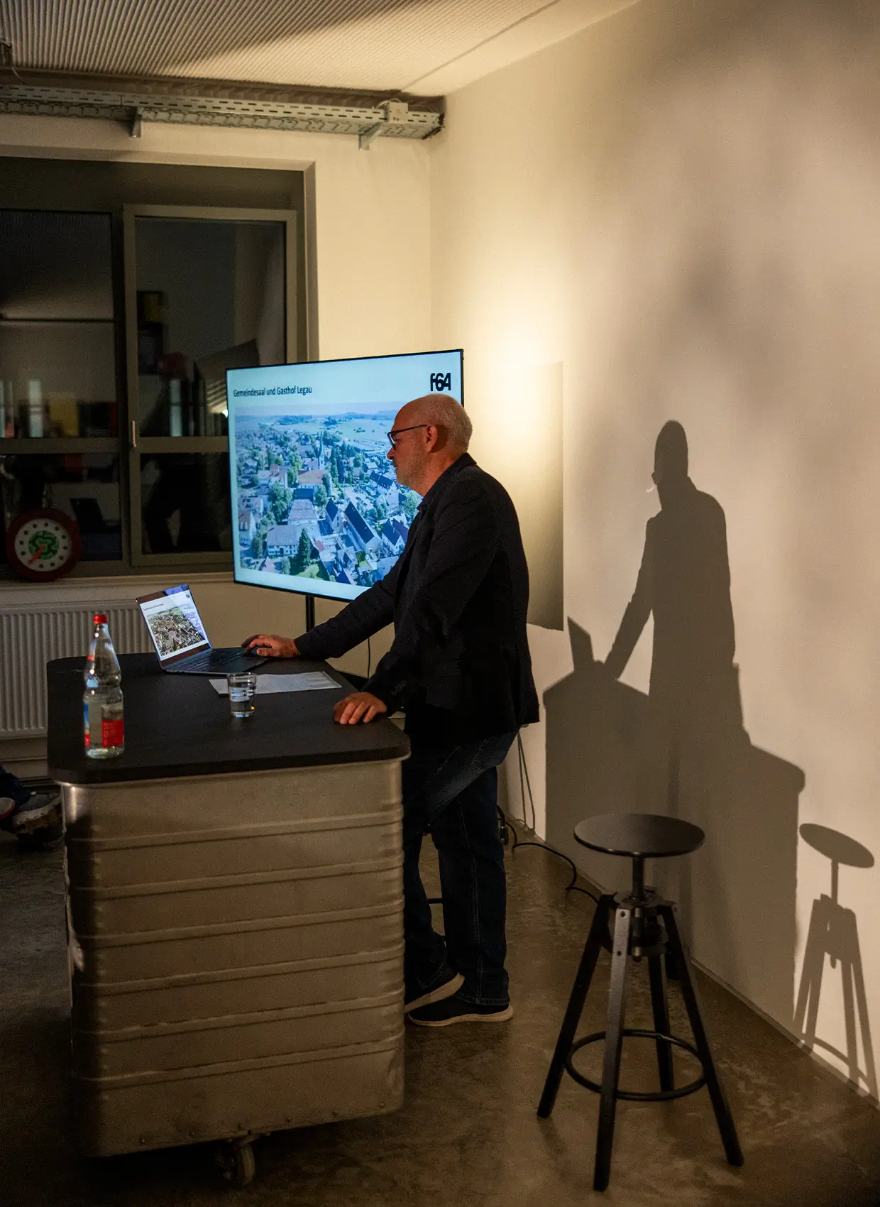 Redner hinter einem Präsentationstisch auf dem Event Stuss & Genuss 2025