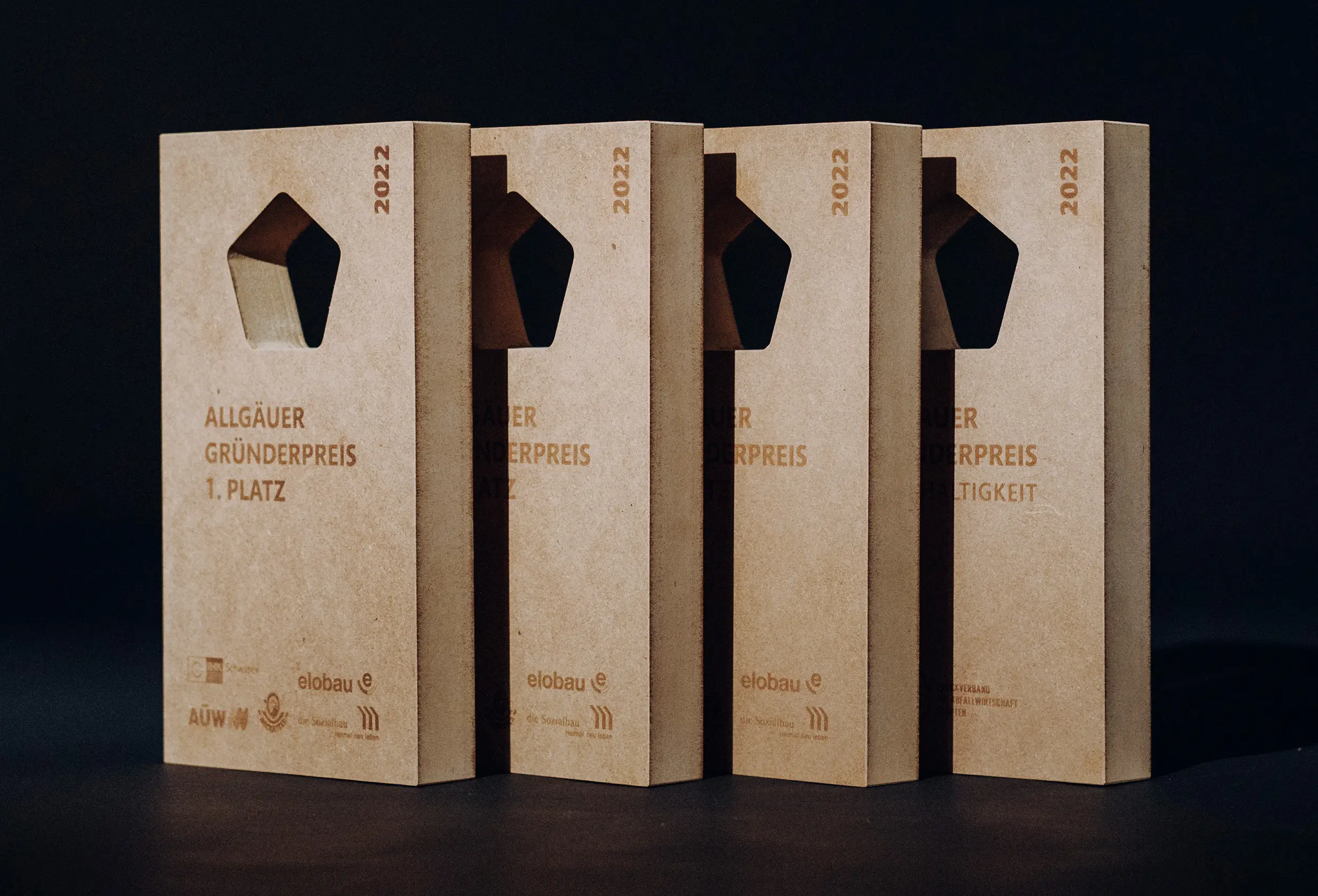 vier Gründerpreis Pokale schräg hintereinander stehend