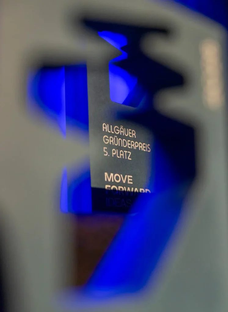 Blick durch die Aussparung eines Pokals auf den Schriftzug eines anderen Pokals