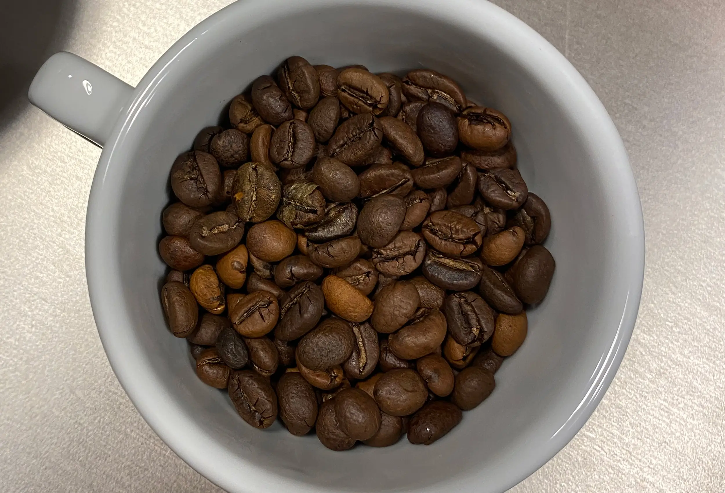 Kaffeetasse von oben, gefüllt mit Kaffeebohnen