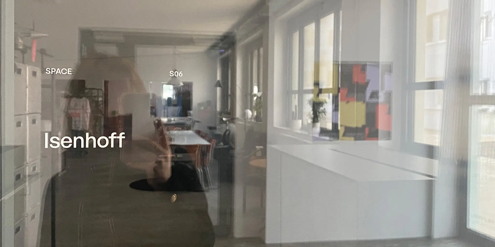 Lea fotografiert sich in der Spiegelung der Tür zum Büro Isenhoff