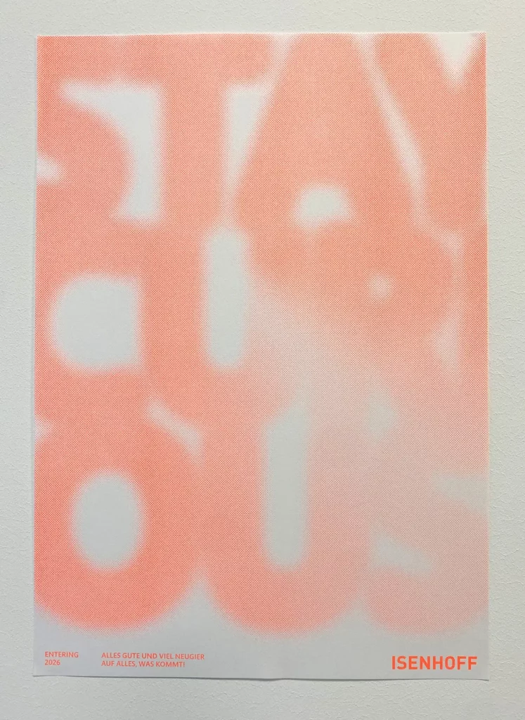 Weihnachtsplakat von Isenhoff 2025. "Stay curious" Schriftzug in knalliger orangener Farbe auf weißem Hintergrund